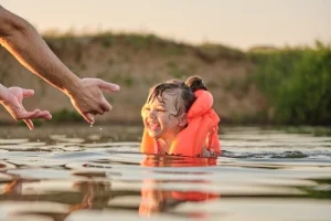 Father teaches daughter to swim.