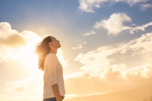 Attractive young woman looking up to the beautiful sky.